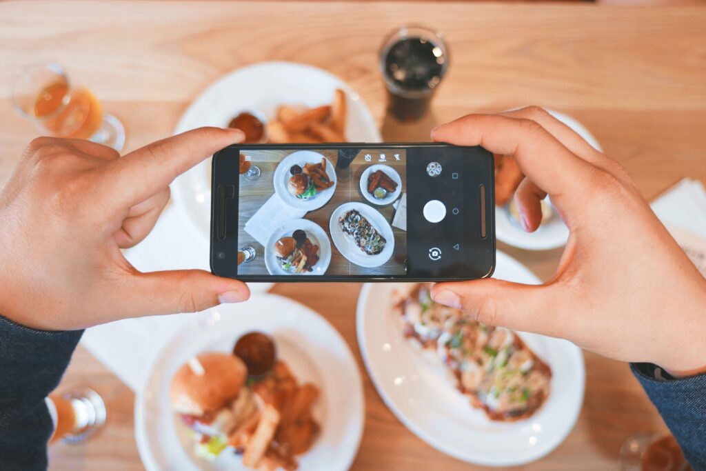 Ein Gast macht ein Bild von seinem Essen für seine Restaurantkritik auf Google und Yelp.